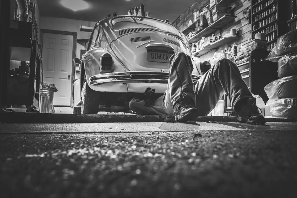 Mecánico trabajando debajo de un coche
